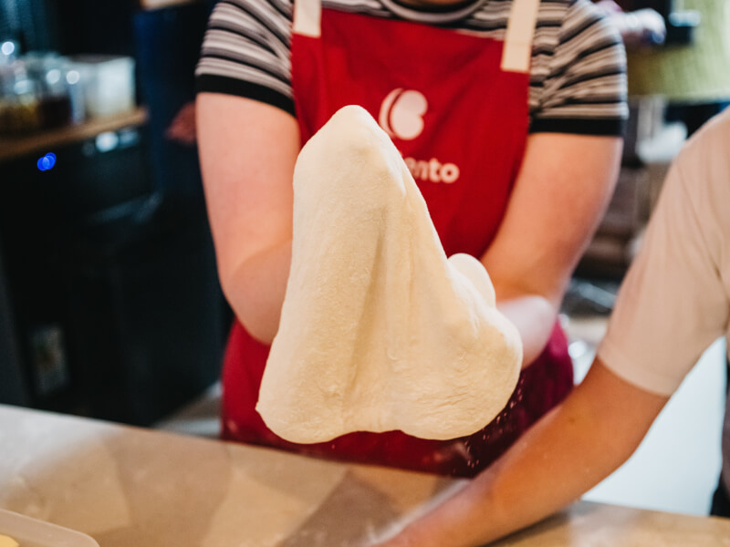 Cooking students works pizza dough at a Melbourne cooking class